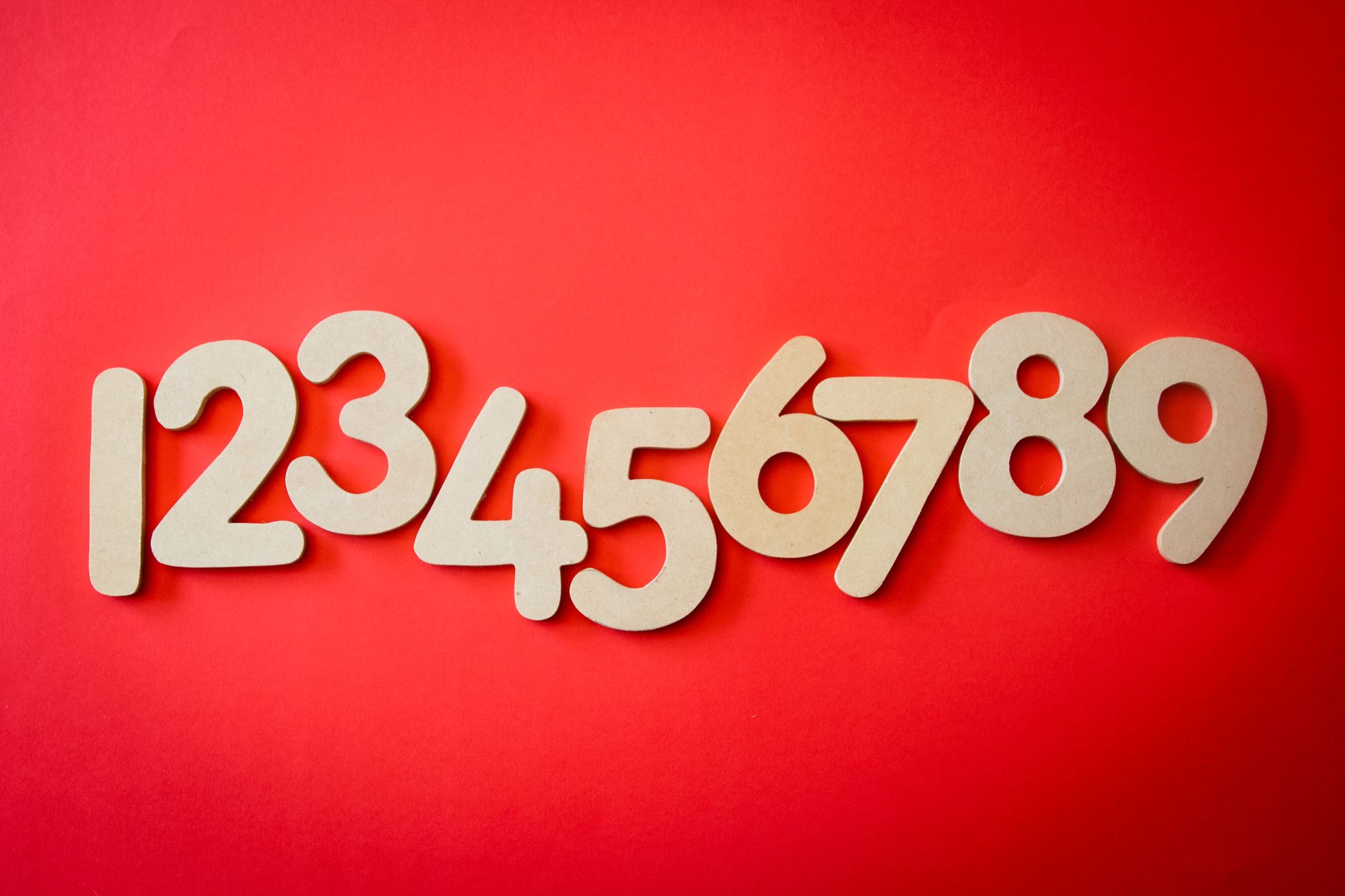 Creative display of numbers one to nine on a vibrant red background, ideal for educational materials.